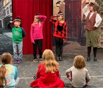 Kids starring in and watching a play